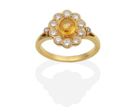 A Yellow Sapphire and Diamond Cluster Ring, an oval cut yellow sapphire within a border of round brilliant cut diamonds in ru