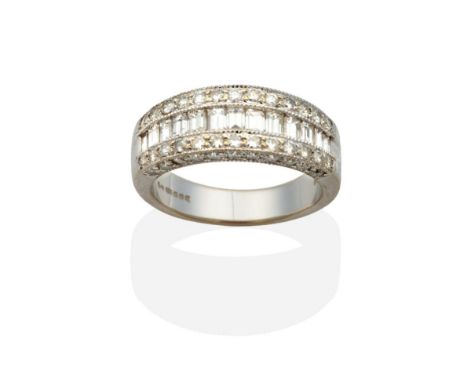 An 18 Carat White Gold Diamond Ring, channel set baguette cut diamonds between rows of grain set round brilliant cut diamonds