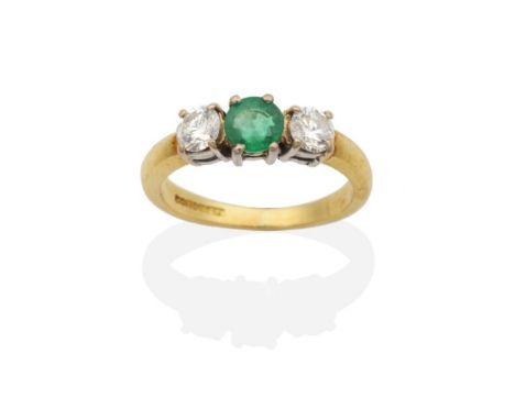 An 18 Carat Gold Emerald and Diamond Three Stone Ring, a round cut emerald between two round brilliant cut diamonds in claw s