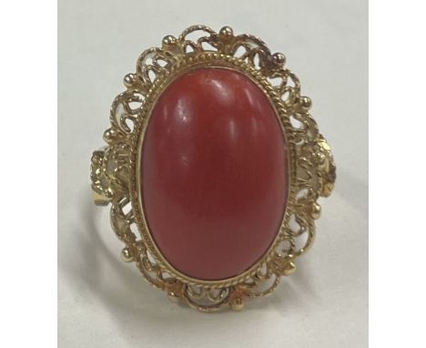 A heavy coral single stone ring in 18 carat gold setting. Approx. 7.3 grams. Est. £150 - £200.