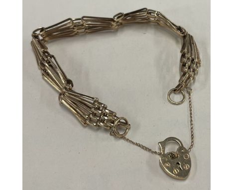 A modern 9 carat gate bracelet with heart shape padlock. Approx. 7 grams. Est. £100 - £150.