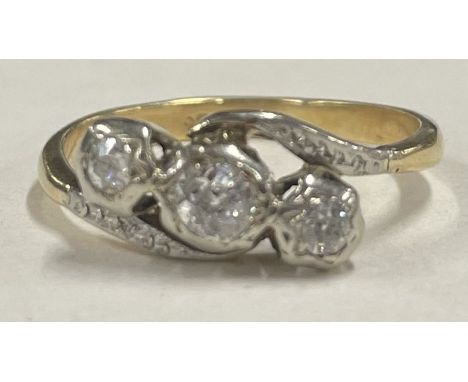 A small diamond three stone crossover ring in 18 carat gold setting. Approx. 2.5 grams. Est. £50 - £80.