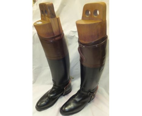 A pair of black hunting boots with brown tops, straps and spurs and wooden trees (size 11)