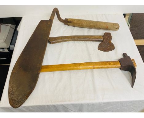 Selection of assoted tools includes a sythe , axe and a pick 