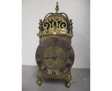 A 19th century brass lantern clock having engraved scroll decoration and surmounted by a bell 