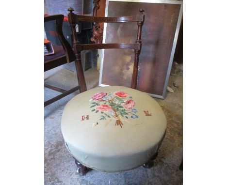 A late 19th century mahogany framed nursing chair with embroidered seat and ceramic castors 