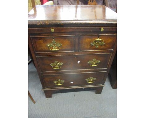 A reproduction straight fronted walnut chest of drawers with brushing slide above two short and two long drawers with bracket