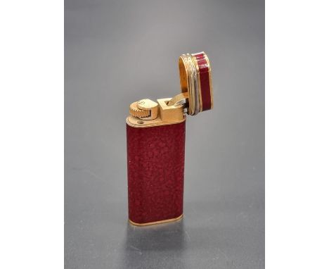 A Cartier red marble lacquer and gold plated lighter, 5.9cm.