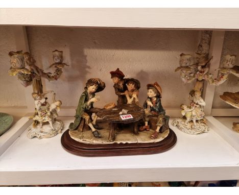 A pair of continental porcelain figural candlesticks, 26.5cm high; together with a Capodimonte figure group, (s.d. to latter)