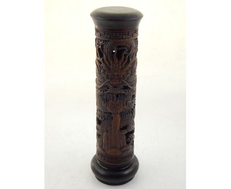 A Chinese carved hardwood incense stick holder, the pierced cylindrical case decorated with a dragon amongst stylised clouds 