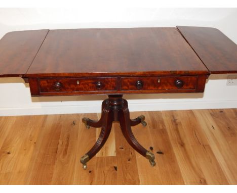 A George IV mahogany sofa table, with rectangular twin flap top over two drawers on carved pillar and quadruple downswept bas