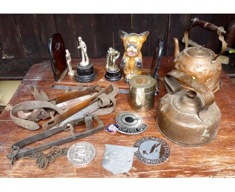 A brass mounted book stand, vintage ice skates, trophy, badges,  two copper kettles, animal trap, dog model, etc.