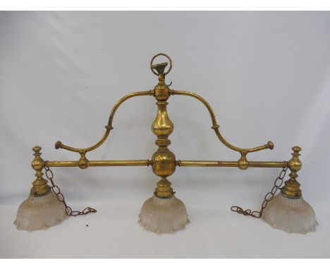 A brass three division light fitting with fluted flared shades. 