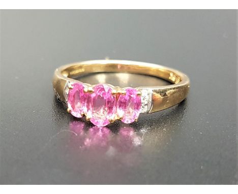 PINK TOPAZ AND DIAMOND RINGthe three graduated oval cut topaz gemstones flanked by two small diamonds to the shoulders, on ni