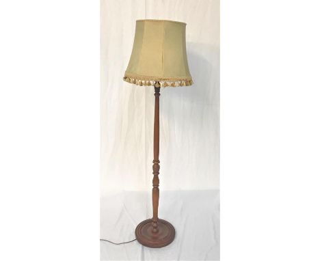 LIGHT OAK STANDARD LAMPraised on a circular base with a turned column and shaped shade, 141cm high excluding shade 