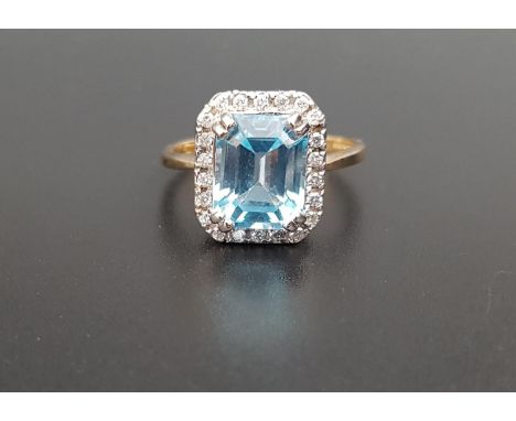 BLUE TOPAZ AND DIAMOND CLUSTER DRESS RINGthe central emerald cut blue topaz approximately 3.3cts in twenty-two diamond surrou