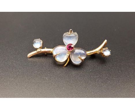 PRETTY MOONSTON AND RUBY BROOCHthe central three moonstones in the form of a three leaf clover, in unmarked gold, 3.6cm long 