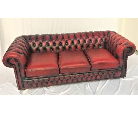 CHESTERFIELD THREE SEAT SOFAin red leather with a button back and scroll arms, with decorative stud detail, 198cm wide 