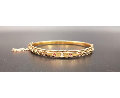 EDWARDIAN DIAMOND AND RUBY FIFTEEN CARAT GOLD BANGLEthe central flush set diamond approximately 0.06cts flanked by rubies and