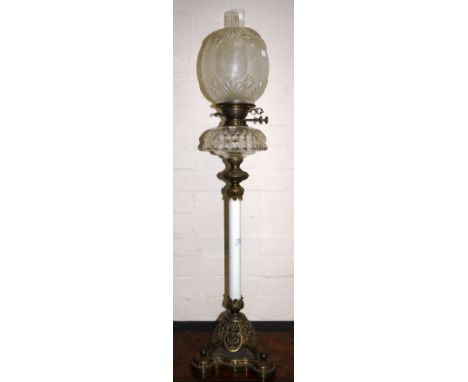 A late Victorian brass oil lamp with white enamel column and cut glass reservoir and moulded glass shade, 38"