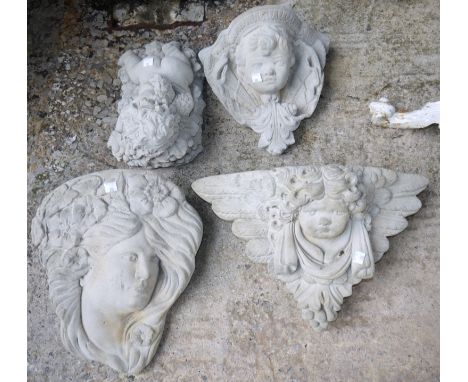 A modern reconstituted stone garden ornament - small cherub on bed of grapes, a similar cherub face planter, 2 similar wall m