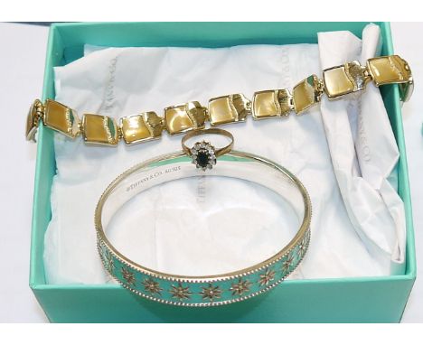 A Tiffany and Co silver bangle with floral beaded turquoise enamel decoration; a 9ct gem set dress ring; a Monet bracelet 