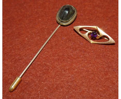 An Edwardian amethyst set bar brooch stamped 375 (1.3gms); a scarab beetle stick pin