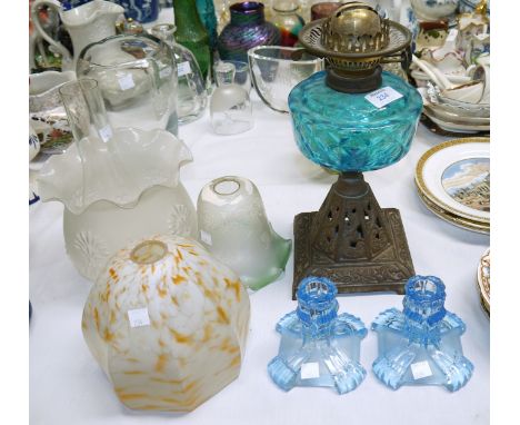 A Victorian cast iron and glass oil lamp; 2 Edwardian glass lamp shades; a pair of glass candlesticks