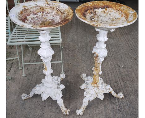 A pair of 19th century cast iron painted bird baths on tripod feet in the classical style