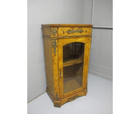 A BURR WALNUT AND GILT BRASS MOUNTED SIDE CABINET the rectangular top with eared corners above a frieze drawer and arched gla