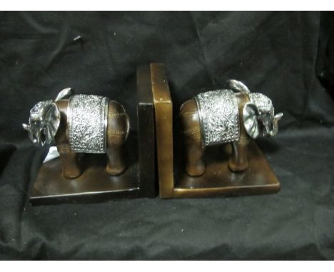 A PAIR OF SILVER PLATED AND COMPOSITION BOOK ENDS each modelled as an elephant shown standing