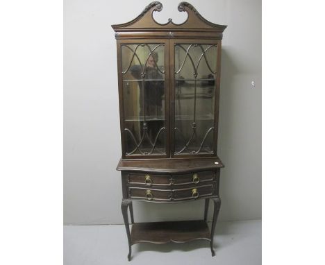 A CHIPPENDALE STYLE MAHOGANY BOOKCASE the swan neck pendament above a pair of astragal glazed doors the base with two long dr