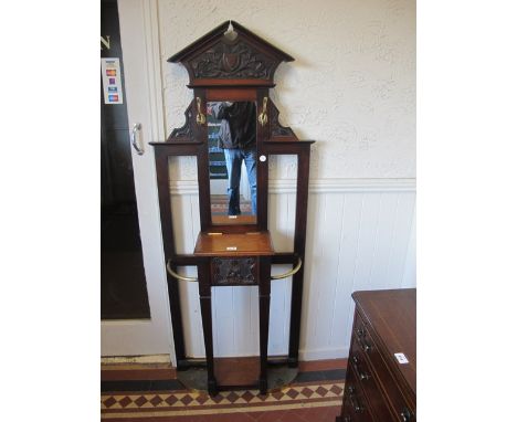 AN EDWARDIAN MAHOGANY HALL STAND the architectural pediment above a rectangular mirror with brass hooks the base with hinged 