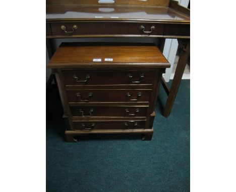 A GEORGIAN STYLE FOUR DRAWER CHEST with brass handles and quarter columns and bracket feet 58cm wide