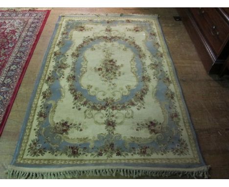 A WOOL RUG the beige and light blue ground with floral pattern 180cm x 120cm
