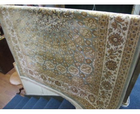 A SILK AND WOOL RUG the light green and beige ground with overall stylized floral panels within a conforming border 140cm x 1