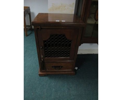 A MEXICAN HARDWOOD SIDE CABINET the rectangular top with grill door and drawer on bracket feet 92cm (h) x 61cm (w) x 49cm (d)