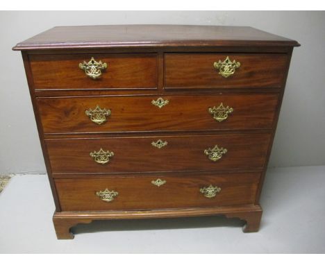 A GEORGIAN MAHOGANY CHEST the rectangular top with broad cross banding above two short and three long drawers with brass drop