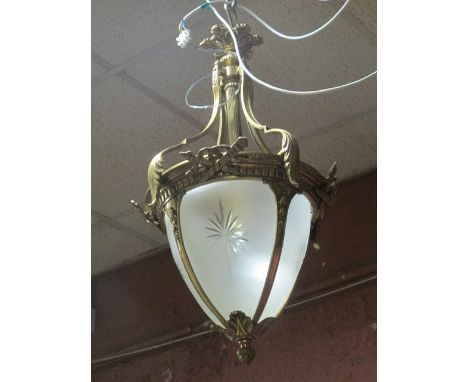 A CONTINENTAL GILT BRASS AND FROSTED GLASS CENTRE LIGHT the circlet hung with stylized foliage decoration above star cut pane