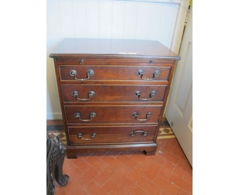 A GEORGIAN STYLE WALNUT CHEST the rectangular top with eared corners above a brushing slide and four long graduated drawers w
