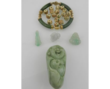 A yellow metal mounted jade segmented bracelet, together with a green hardstone figure of a Buddha, two small hardstone carvi