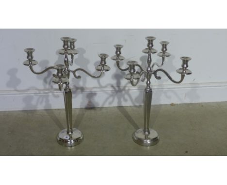 A pair of plated five light candelabra on round bases