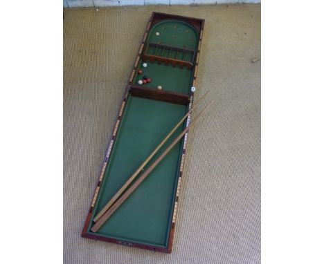 A mahogany folding table top Bagatelle with two cues - Total length 1.83 m x 46 cm 