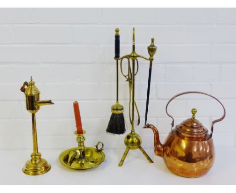 Copper and brass wares to include a kettle, watering can, Victorian chamber stick, brass trivet and fireside companion set, (