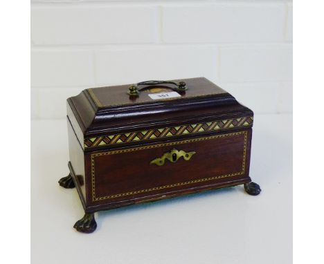 An Edwardian mahogany and chequer banded tea caddy, the rectangular top with shell paterae and brass handle, opening to revea