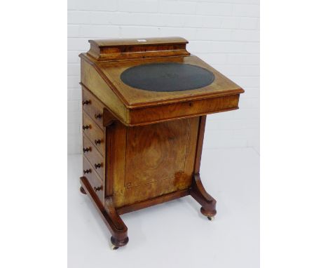 A Victorian walnut and tulip wood banded Davenport, the lift up top with oval leather skivver, on bun feet and ceramic castor