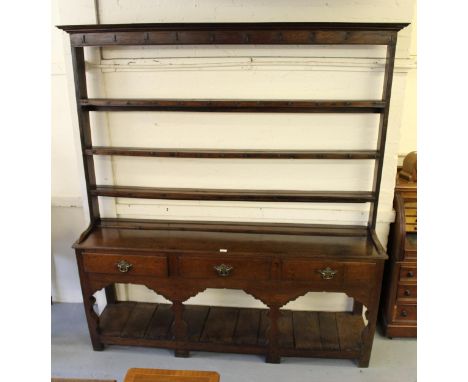 George III oak dresser, the open shelf back above three drawers and a three bay base with pot shelf, on shaped stile supports