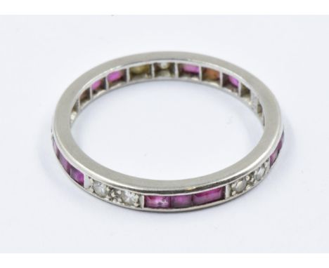 White metal ruby and diamond set eternity ringWeight is 2.8g. Size M1/2-N. Chip to one ruby. Metal has light scratching.