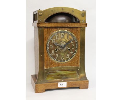 Arts &amp; Crafts oak and brass mounted mantel clock, the circular brass dial with embossed Arabic numerals and two train mov