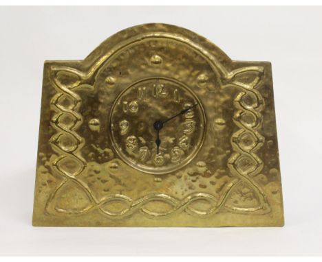 Arts and Crafts repousse brass mantel clock, the circular dial with Arabic numerals, within a shaped case with stylised relie